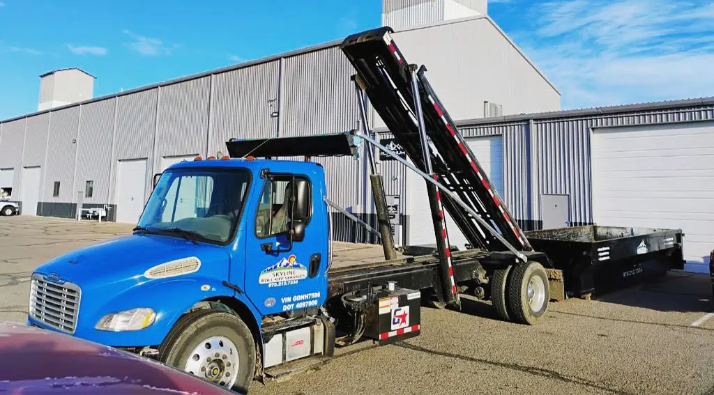 skyline roll off services truck in front of warehouse with dumpster